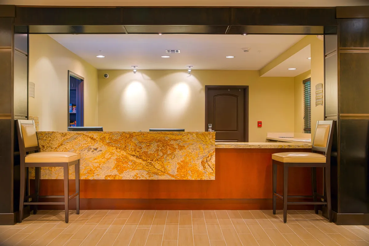 The hotel’s reception area features a granite countertop, comfortable chairs, and a warm, welcoming atmosphere. The reception staff is ready to assist, setting an inviting tone for guests as they start their day or return from breakfast.